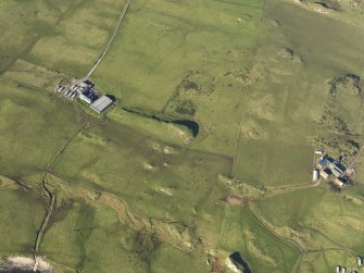 Oblique aerial view of the dun and Pennyseorach farmstead, taken from the SE.