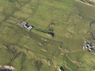 Oblique aerial view of the dun and Pennyseorach farmstead, taken from the SE.