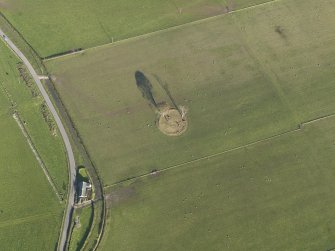 Oblique aerial view centred on the remains of the stone circle, taken from the W.