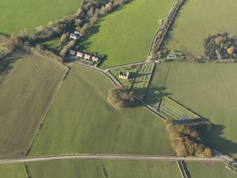 Oblique aerial view centred on the church and the remains of the earthwork, taken from the SSE.