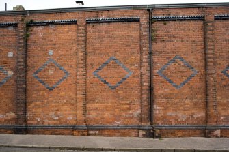 Detail of decorative brickwork on S wall of depot from S.