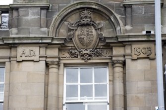 Detail of carved Royal Arms and date on front elevation from SSE.