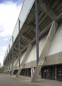 Detailed view of Meadowbank Stadium from the east, showing the exposed concrete structure of the grandstand and concrete panels at concourse level.