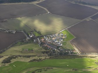 Oblique aerial view centred on the village with the parish church adjacent, taken from the N.