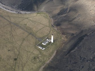 Oblique aerial view centred on the lighthouse with the keepers cottages adjacent, taken from the SE.