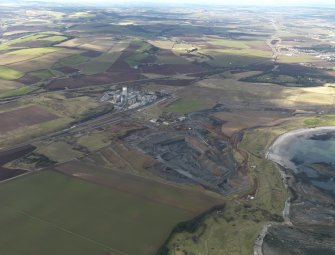 General oblique aerial view centred on the cement works with the open cast extraction adjacent, taken from the E.