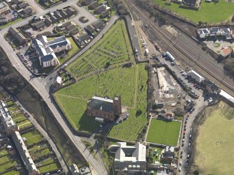 Oblique aerial view centred on the parish church with the railway station adjacent, taken from the NW.