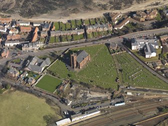 Oblique aerial view centred on the  parish church with the railway station adjacent, taken from the SW.