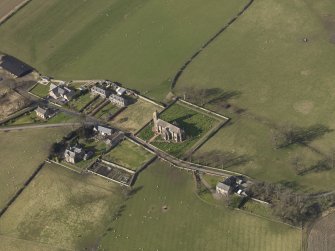 Oblique aerial view centred on the village with the church adjacent, taken from the SE.