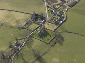 Oblique aerial view centred on the village with the church adjacent, taken from the NE.