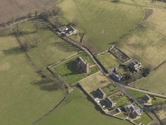 Oblique aerial view centred on the village with the church adjacent, taken from the WNW.