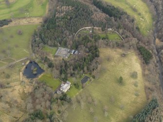 Oblique aerial view centred on the country house with the home farm and walled garden adjacent, taken from the SW.