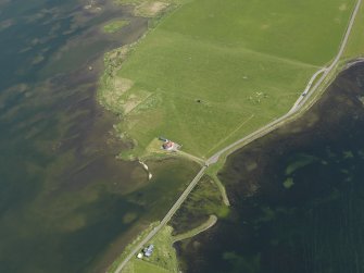 Oblique aerial view centred on the Bridge of Brodgar with The Watch Stone, the Stones of Stenness and the Barnhouse settlement adjacent, taken from the WNW.