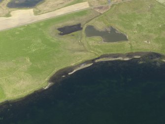 Oblique aerial view centred on the remains of the barrow at Bookan, taken from the SW.