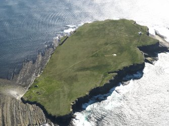 General oblique aerial view of the Brough of Birsay with the lighthouse to the top right and the monastic settlement to the bottom left, taken from the NE.