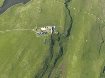 Oblique aerial view centred on the burial ground at Scockness with Scockness Farm adjacent, taken from the S.