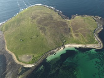 General oblique aerial view of Eynhallow with the ruins of the monastery to the left and the remains of a possible farmstead to the right, taken from the SE.