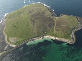 General oblique aerial view of Eynhallow with the ruins of the monastery to the left and the remains of a possible farmstead to the right, taken from the SE.