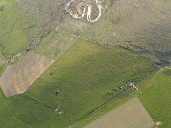 Oblique aerial view centred on the ruins of the farmstead and field boundaries at Hill of Borwick with the remains of a firing range adjacent, taken from the NE.