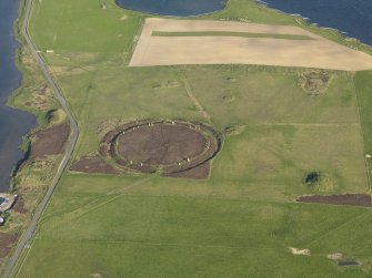 Oblique aerial view centred on the Ring of Brodgar with the cairns adjacent, taken from the NW.