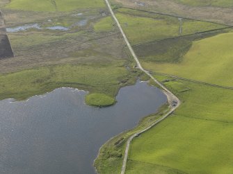 Oblique aerial view centred on an island in the Loch of Wasdale with the remains of a farmstead adjacent, taken from the SE.