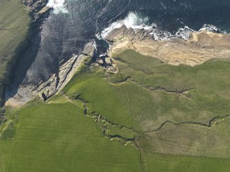 Oblique aerial view centred on the Broch of Borwick and the remains of the rig and furrow, taken from the SW.