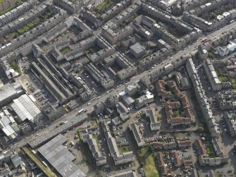 Oblique aerial view centred on the N end of Leith Walk with the former tram depot adjacent, taken from the NW.