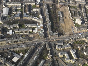 Oblique aerial view centred on Leith Walk with the site of the former tram and bus depot adjacent, taken from the SE.