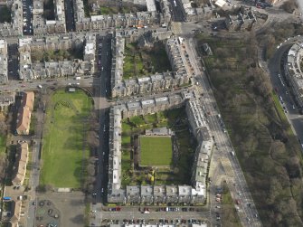 Oblique aerial view centred on the bowling green with tenements adajacent, taken from the W.