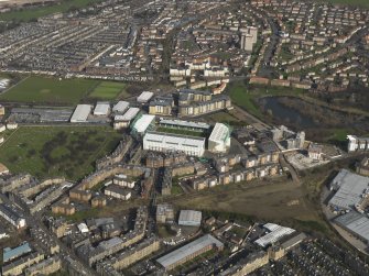 General oblique aerial view centred on the football stadium, taken from the SW.