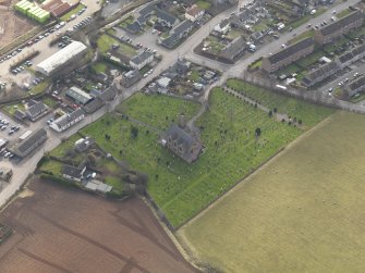 Oblique aerial view of the church with the churchyard adjacent, taken from the NE.