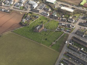 Oblique aerial view of the church with the churchyard adjacent, taken from the NW.