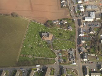 Oblique aerial view of the church with the churchyard adjacent, taken from the WSW.