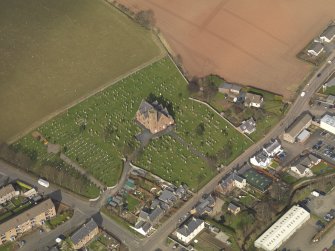 Oblique aerial view of the church with the churchyard adjacent, taken from the SW.