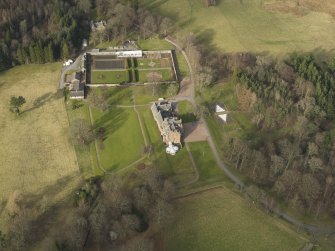 Oblique aerial view centred on the country house with the walled garden, taken from the S.