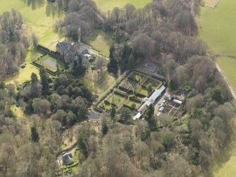 Oblique aerial view centred on the country house with the walled garden adjacent, taken from the NE.