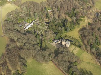 Oblique aerial view centred on the country house with the walled garden adjacent, taken from the SW.