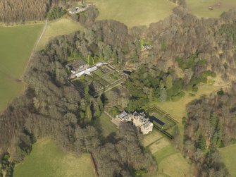 Oblique aerial view centred on the country house with the walled garden adjacent, taken from the SSW.