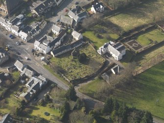Oblique aerial view centred on the old parish church with the graveyard adjacent, taken from the ESE.