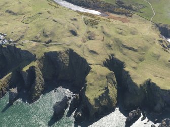 General oblique aerial view of the defended promontary and possible nunnery with St Abb's Head Lighthouse adjacent, taken from the N.