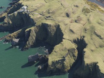 General oblique aerial view of the defended promontary and possible nunnery with St Abb's Head Lighthouse adjacent,, taken from the NW.