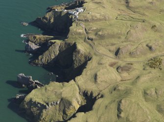 General oblique aerial view of the defended promontary and possible nunnery with St Abb's Head Lighthouse adjacent, taken from the WNW.
