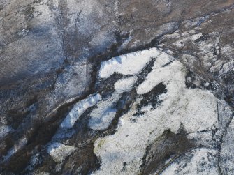 Oblique aerial view centred on the remains of the building, field banks and rig and furrow, taken from the NNE.