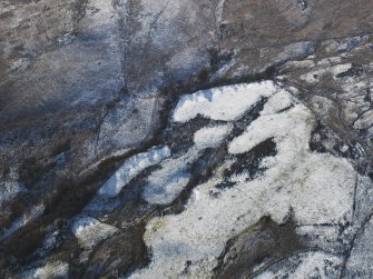 Oblique aerial view centred on the remains of the building, field banks and rig and furrow, taken from the NNE.