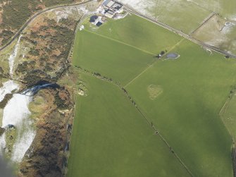 Oblique aerial view centred on the remains of the cairn with the remains of the dun adjacent, taken from the S.