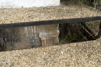 Interior. W range, detail of original stonework at ground level