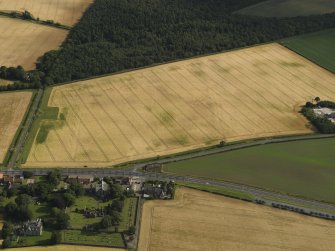 General oblique aerial view of the cropmarks of the field boundary and the modern feature looking across Glasmuir and the Old Parish Church, taken from the NNW.