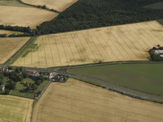 General oblique aerial view of the cropmarks of the field boundary and the modern feature looking across Glasmuir and the Old Parish Church, taken from the NW.