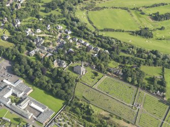 Oblique aerial view of Inveresk Parish Church and the site of the Roman Fort, taken from the NNE.