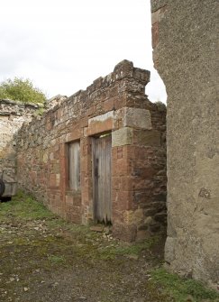 View from SSW showing surviving section of building with coach recess on gable end of house.